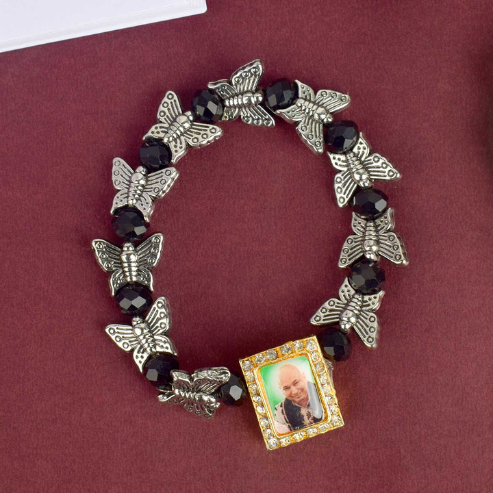 Chic Guruji Swaroop Bracelet featuring black beads and silver butterfly charms, handcrafted for spiritual elegance and daily devotion. India’s Largest Pooja Accessories Brand – www.satvikworld.com