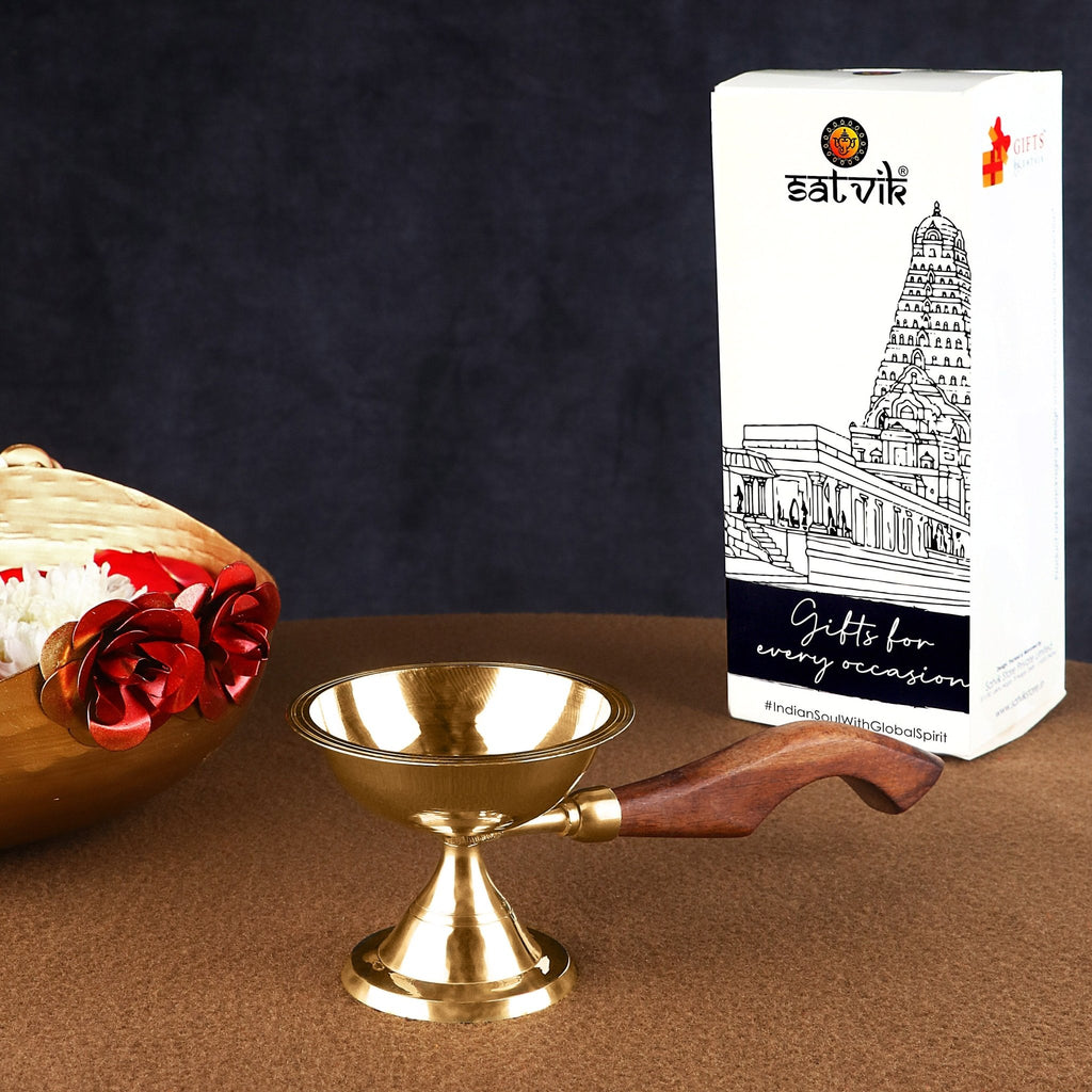Fascinating Aarti Diya with Curved Wooden Handle – A traditional brass oil lamp with an ergonomically curved wooden handle for safe and graceful aarti rituals during puja. India’s Largest Pooja Accessories Brand – www.satvikworld.com