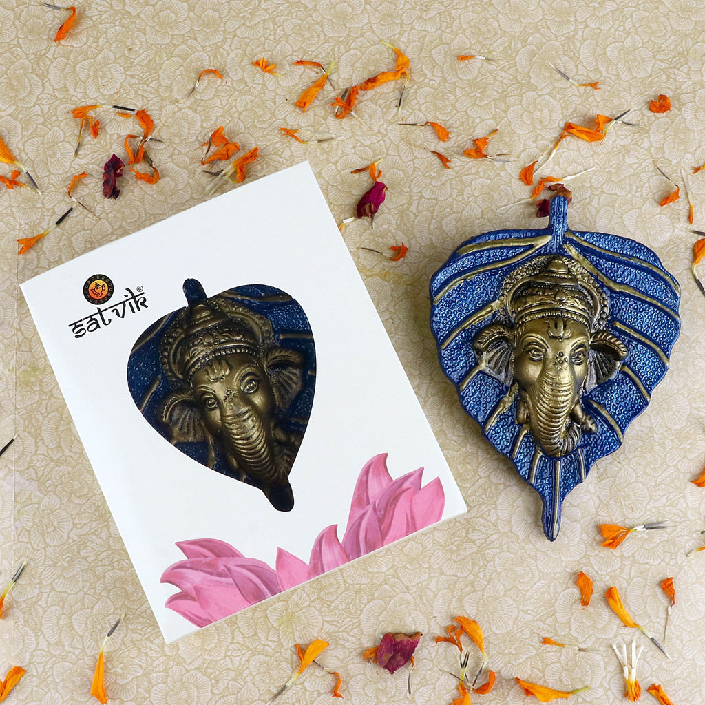 1 Pc Lord Ganesh face beautifully carved on a blue leaf patta wall hanging for traditional and spiritual home décor. India’s Largest Pooja Accessories Brand – www.satvikworld.com